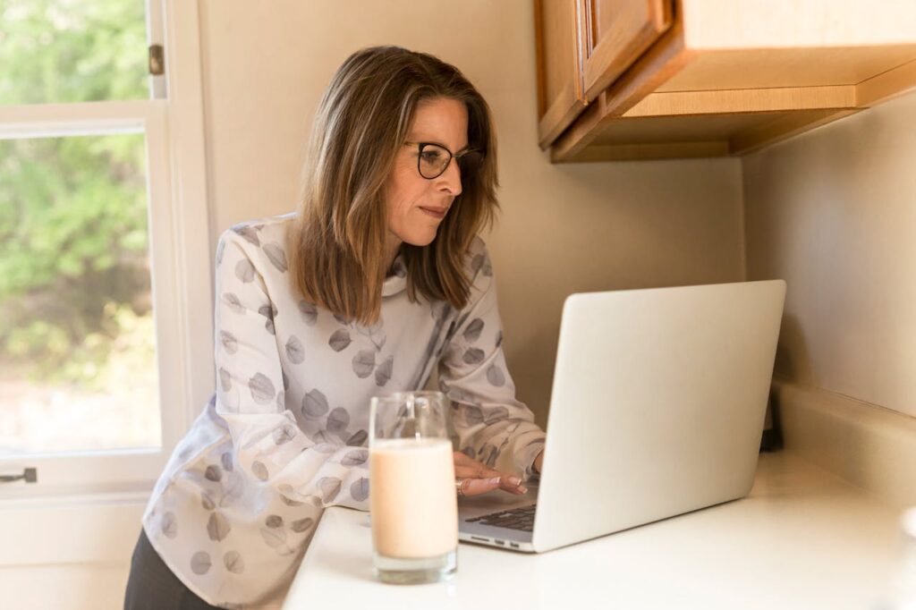 une femme qui en t&eacute;l&eacute;travail dans sa cuisine
